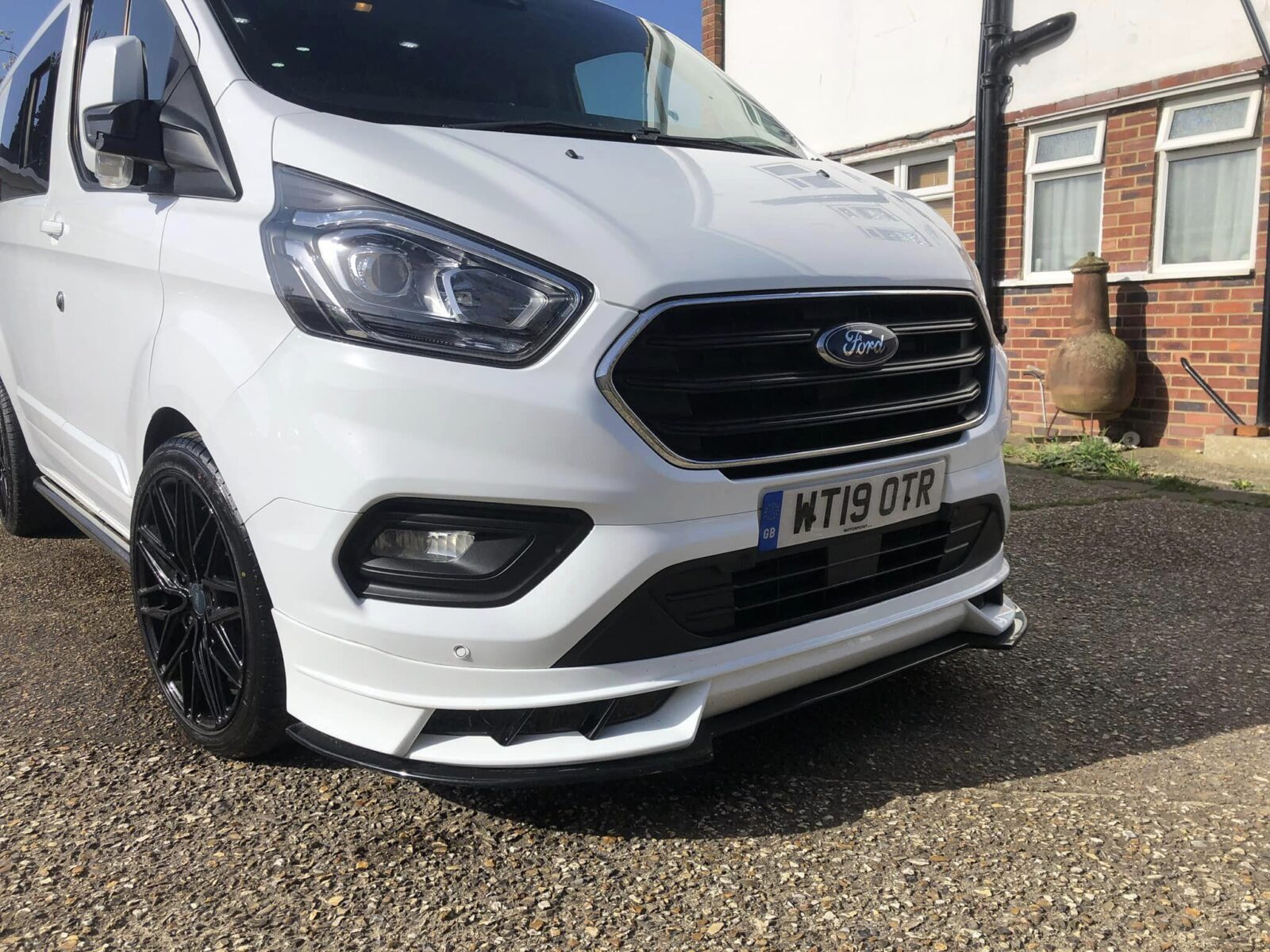 A white Ford Transit Custom with the V1 Front splitter installed