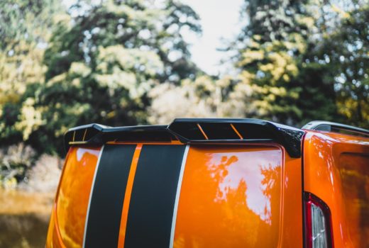 A Ford Transit Custom Roof spoiler in Black sat on a orange Ford Transit Custom Tailgate