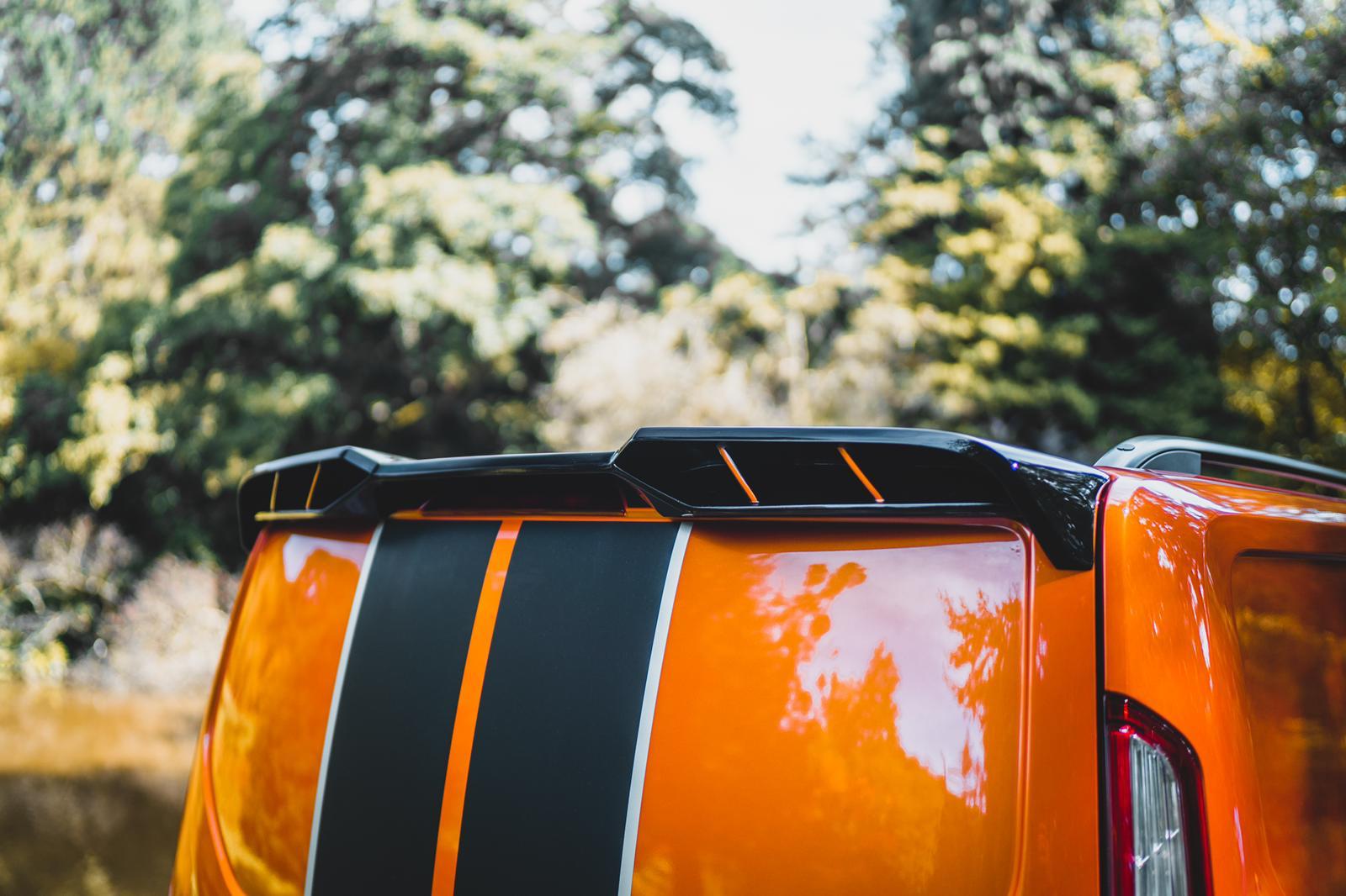 A Ford Transit Custom Roof spoiler in Black sat on a orange Ford Transit Custom Tailgate